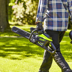 Greenworks motosierra en uso cortando rama, potencia y control visibles