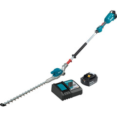 Makita XNU01T en uso recortando setos altos, alcance extendido sin escalera