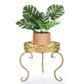OwnMy soporte dorado frontal mostrando maceta y decoración
