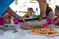 Cuisinart cortador en uso cortando una pizza grande con un movimiento de balanceo