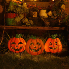 Juegoal calabaza clavada en camino de jardín creando sendero iluminado