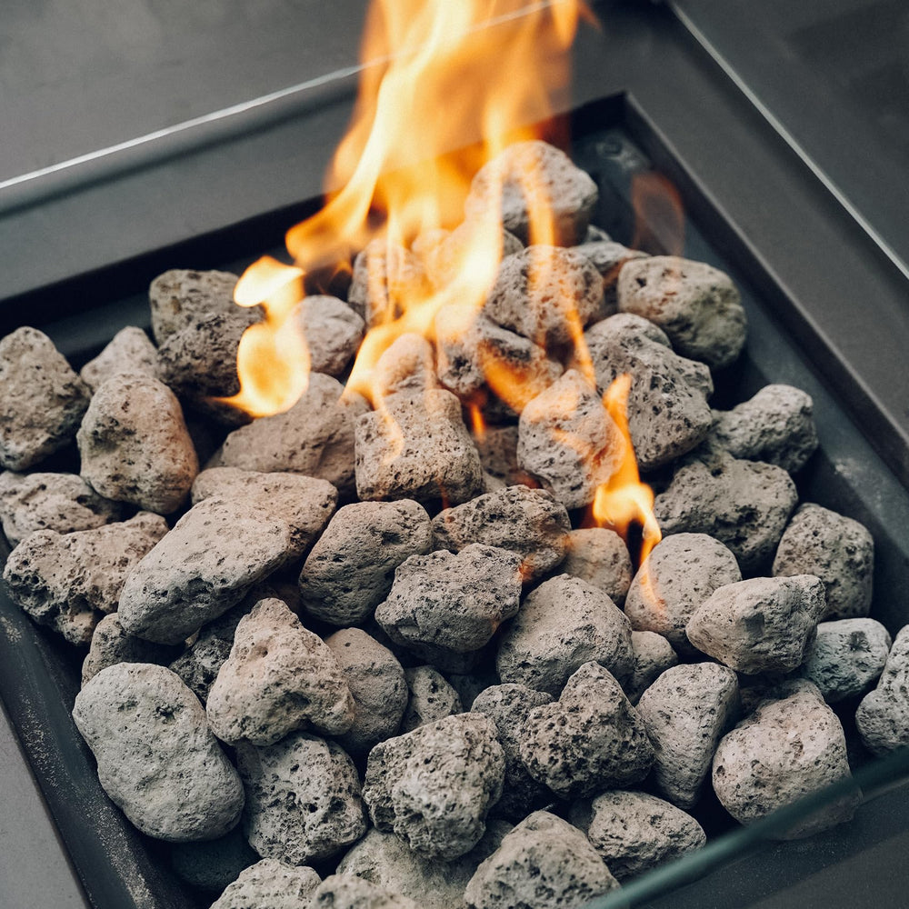 Skyflame mano sosteniendo piedras para demostrar tamaño práctico